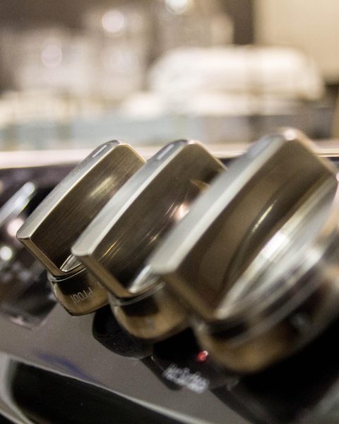 Een strakke keramische kookplaat ingebouwd in een donker werkblad van een moderne designkeuken