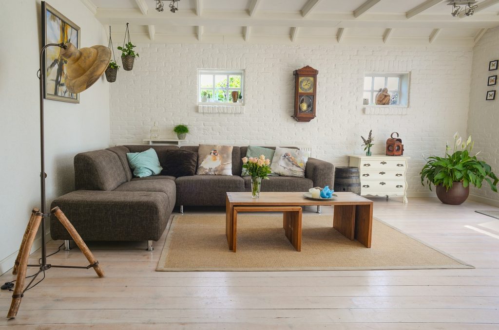 Landelijke woonkamer met een robuuste salontafel in massief hout, linnen gordijnen en aardetinten
