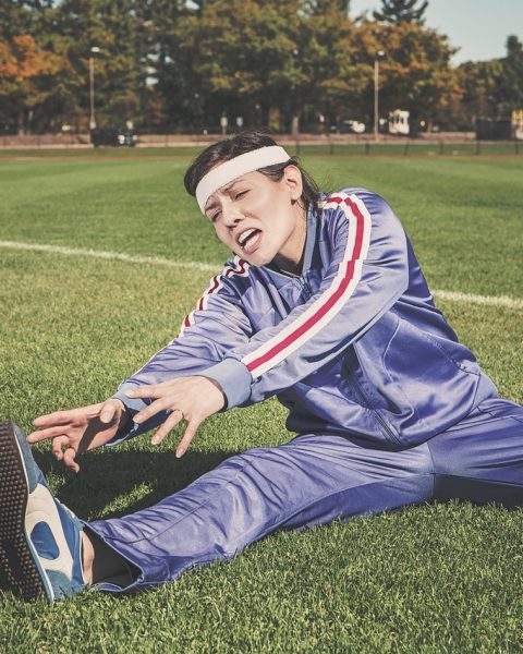 Vrouw in luxe trainingspak gecombineerd met blazer en loafers als werkoutfit