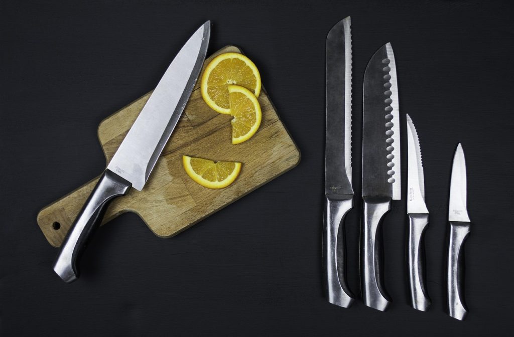 Elegante keuken met een rij scherpe messen op een houten magneetstrip boven het aanrecht