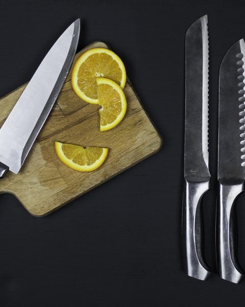 Elegante keuken met een rij scherpe messen op een houten magneetstrip boven het aanrecht