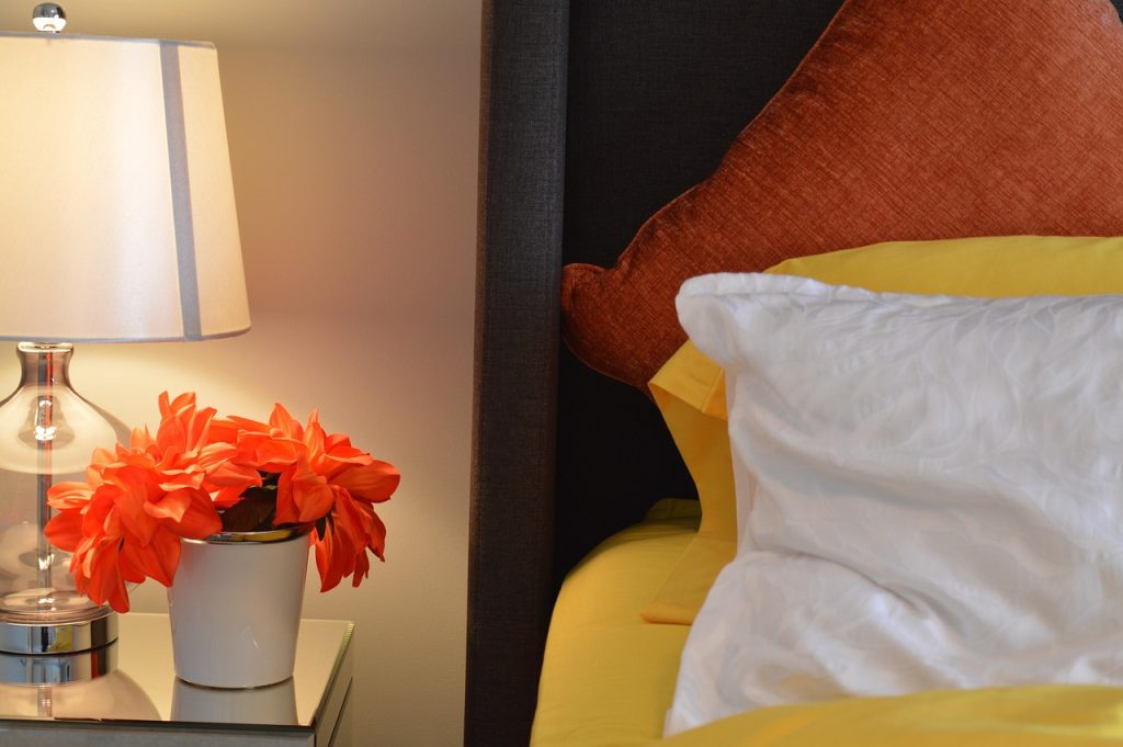 Stijlvolle nachtkastlamp op een marmeren voet naast een opgemaakt bed in een moderne slaapkamer