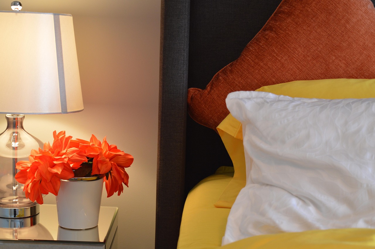 Stijlvolle nachtkastlamp op een marmeren voet naast een opgemaakt bed in een moderne slaapkamer