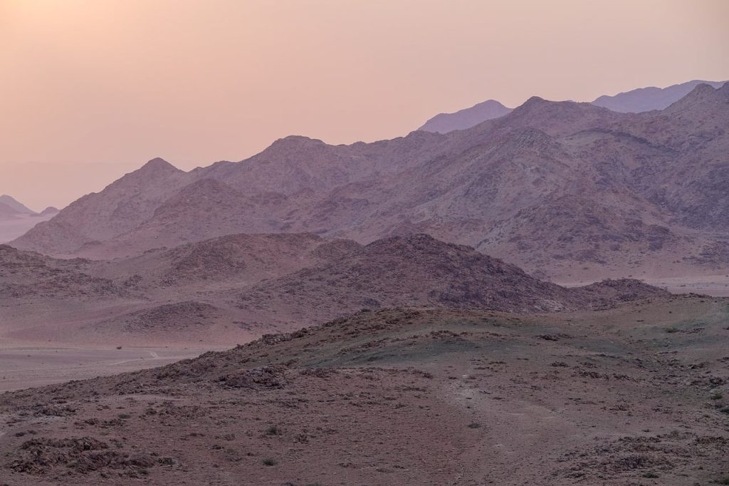 Rode zandduinen van Sossusvlei in Namibië tijdens zonsondergang met warme kleuren