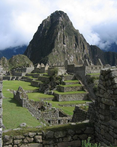 Uitzicht op de Inca-ruïnes van Machu Picchu bij vroeg ochtendlicht met mist in de bergen
