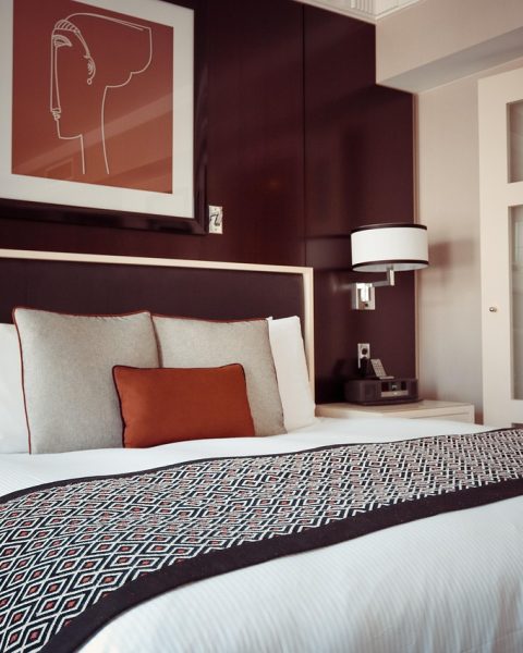 Luxueuze hotelkamer met warme kleuren, zachte verlichting en stijlvol beddengoed