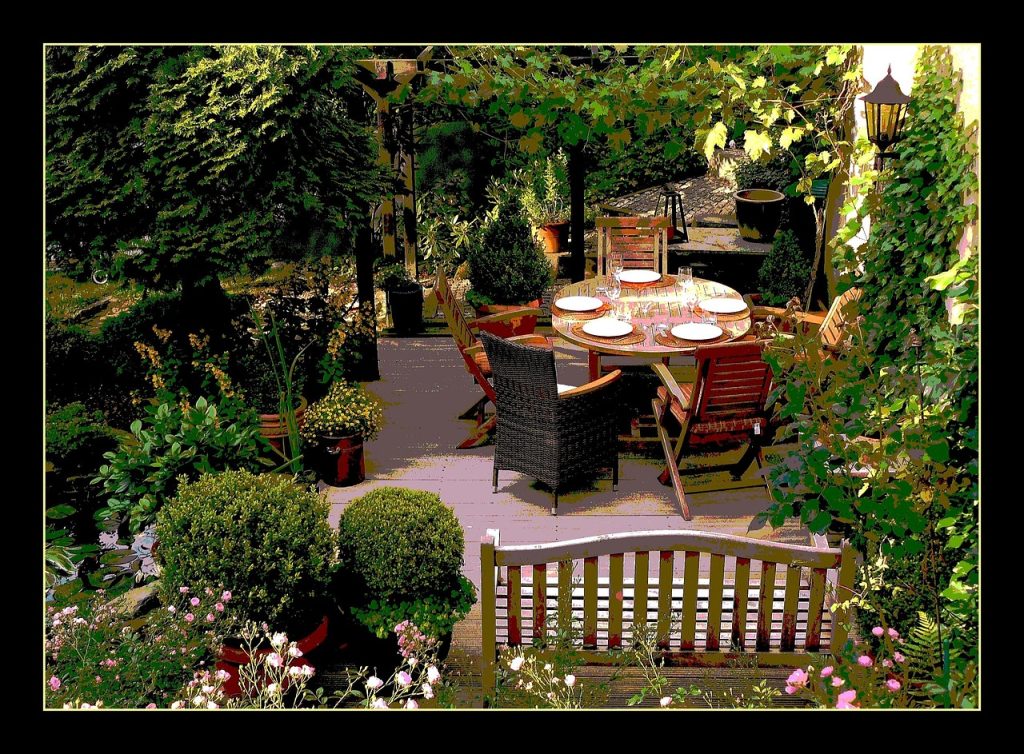 Chique gedekte tafel op een zomers terras met linnen loper, aardewerk en kaarsen in terracottahouders