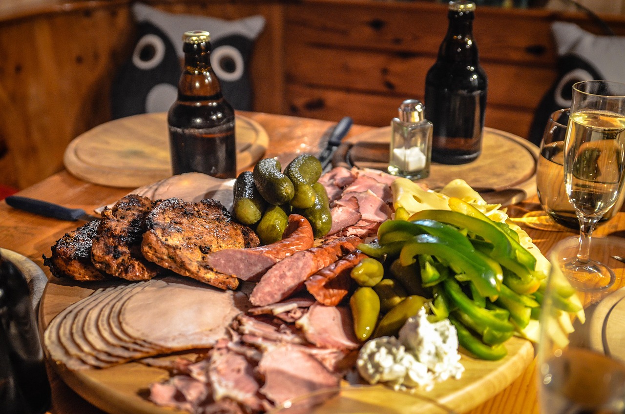 Een stijlvol opgemaakt charcuterie bord met dun gesneden vleeswaren, kaas en garneringen op een houten plank