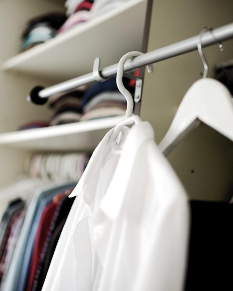 Netjes georganiseerde kleine kledingkast met fluwelen hangers en stapeldozen
