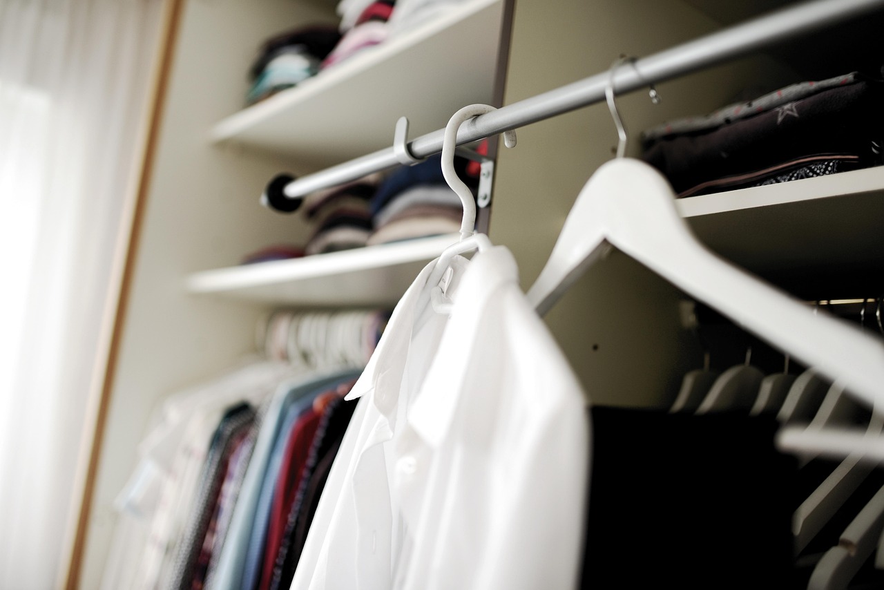 Netjes georganiseerde kleine kledingkast met fluwelen hangers en stapeldozen